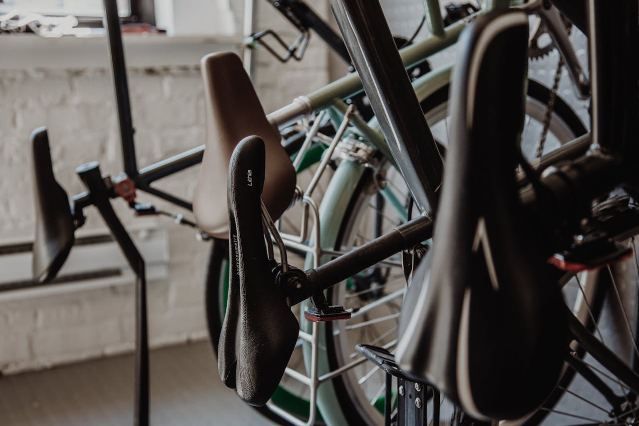Close-up view of bicycle seats and wheels in an indoor shop setting. Ideal for transportation and bicycle-related themes.
